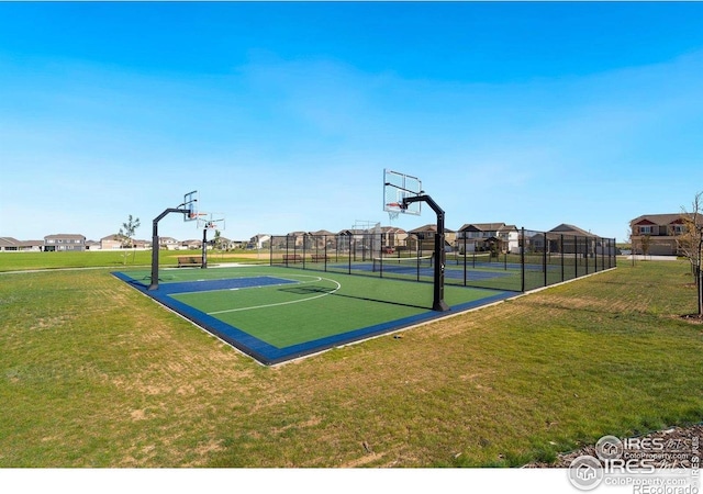 view of basketball court featuring community basketball court, fence, a residential view, and a lawn
