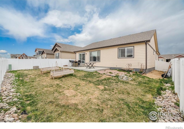 back of property with a lawn, a fenced backyard, and a patio