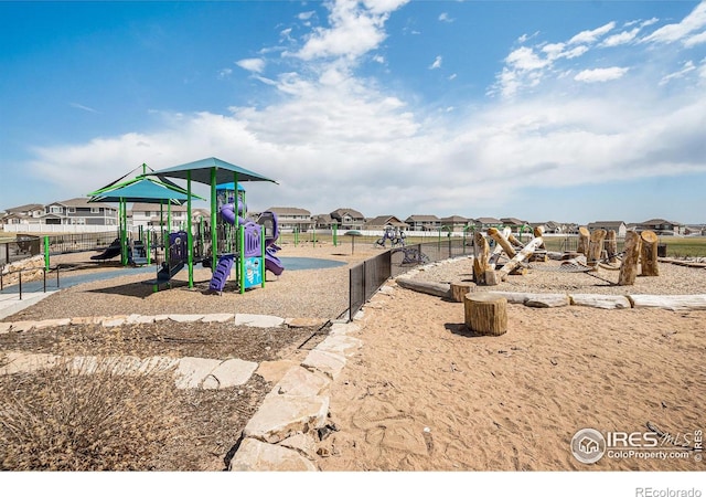 community playground featuring fence and a residential view
