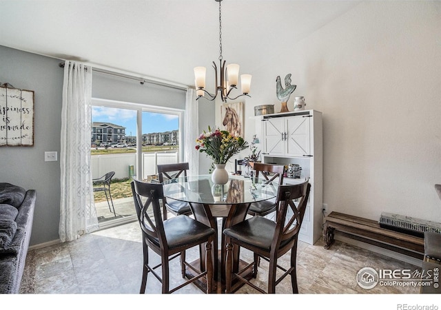 dining room featuring a chandelier and baseboards