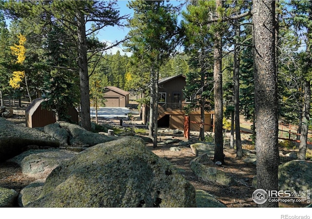 10649 Christopher Dr, Conifer, CO 80433 - view of yard with a wooden deck, stairs, a garage, and an outdoor structure