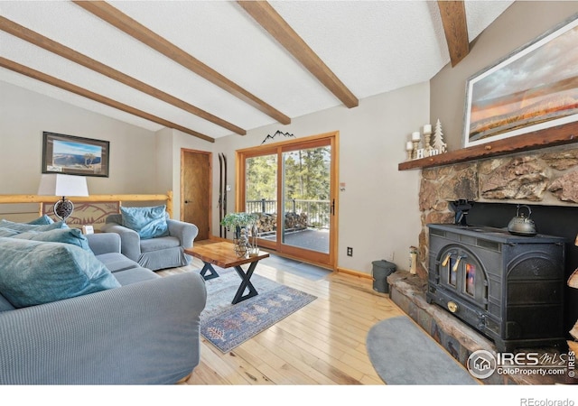 10649 Christopher Dr, Conifer, CO 80433 - living room with baseboards, vaulted ceiling with beams, wood finished floors, and a wood stove