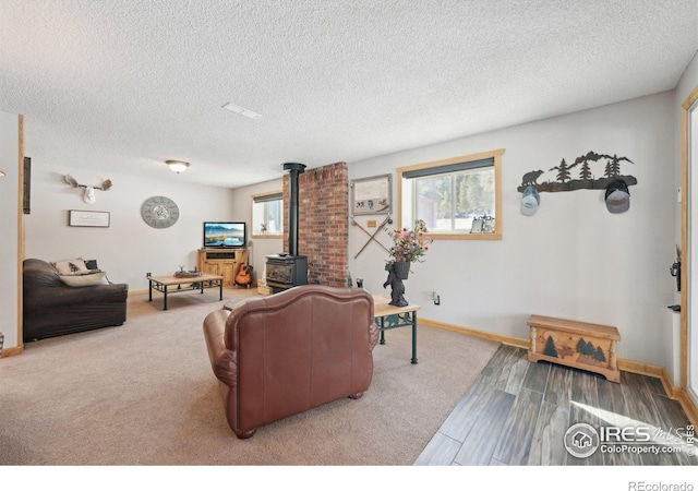 10649 Christopher Dr, Conifer, CO 80433 - living area with baseboards, a wealth of natural light, a textured ceiling, and a wood stove