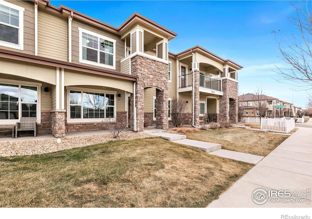 view of front of home featuring stone siding and a front lawn