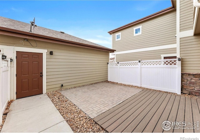wooden deck with fence and a patio area
