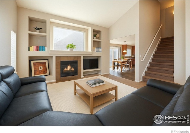 4774 Coker Ave, Castle Rock, CO 80104 - living area with built in shelves, stairs, baseboards, a tile fireplace, and lofted ceiling