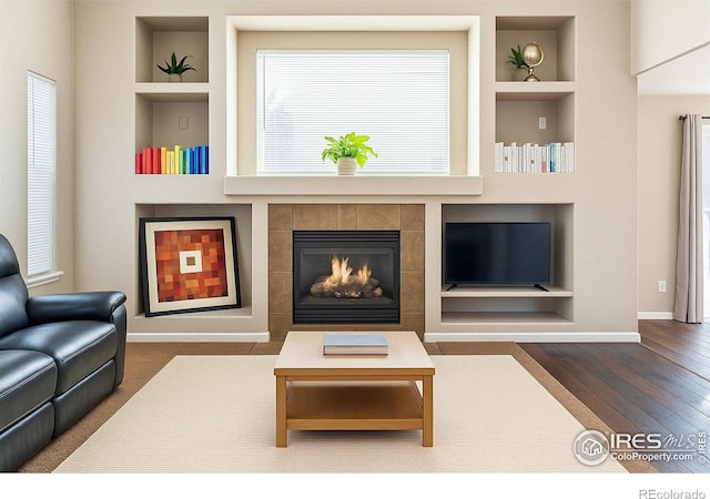 4774 Coker Ave, Castle Rock, CO 80104 - living area featuring built in shelves, baseboards, wood finished floors, and a fireplace