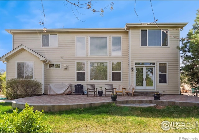 rear view of property with french doors, a yard, and a patio area