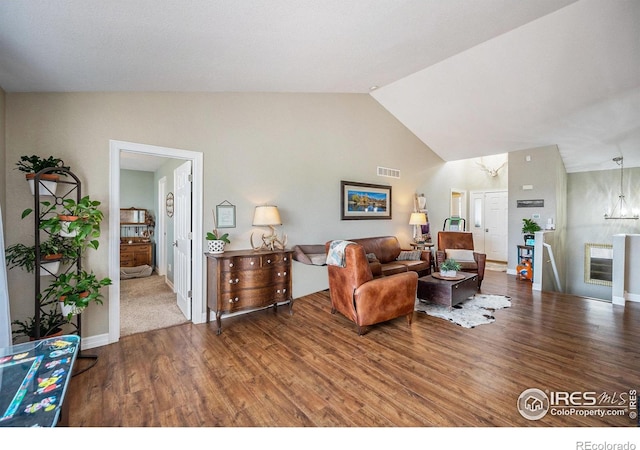 2190 Coyote Creek Dr, Fort Lupton, CO 80621 - living area featuring wood finished floors, high vaulted ceiling, and baseboards