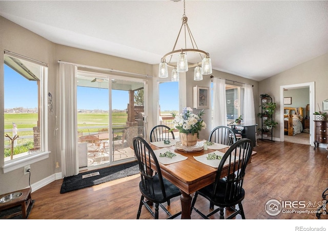2190 Coyote Creek Dr, Fort Lupton, CO 80621 - dining space featuring wood finished floors, baseboards, vaulted ceiling, and view of golf course