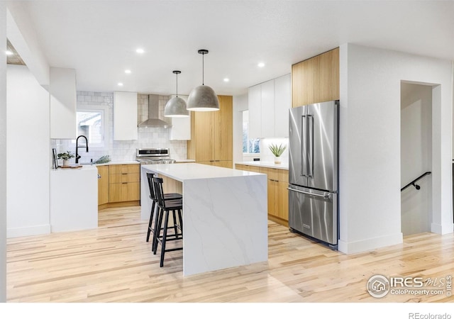 1012 Hobson Ct, Fort Collins, CO 80526 - kitchen with high quality fridge, wall chimney exhaust hood, modern cabinets, a breakfast bar area, and a center island