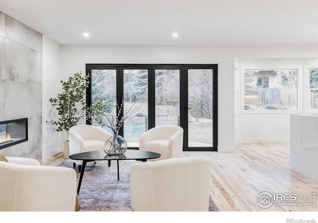 1012 Hobson Ct, Fort Collins, CO 80526 - living room featuring a tiled fireplace, healthy amount of natural light, wood finished floors, recessed lighting, and baseboards