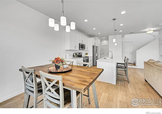 dining area with light wood finished floors, baseboards, and recessed lighting