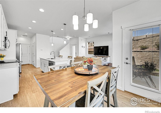 dining room with recessed lighting, a chandelier, and light wood-type flooring