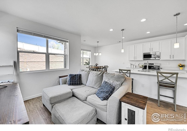 living room featuring recessed lighting, light wood-style floors, and baseboards