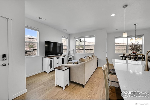 living area with recessed lighting, light wood-type flooring, visible vents, and baseboards