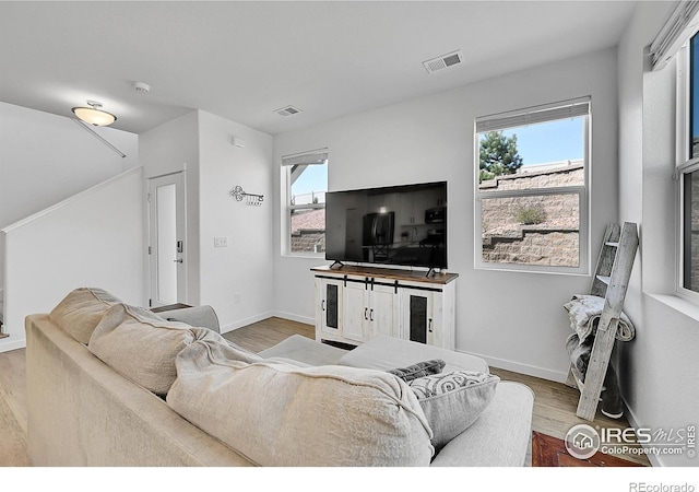 living area featuring wood finished floors and visible vents