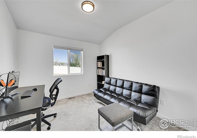 home office featuring carpet, lofted ceiling, visible vents, and baseboards