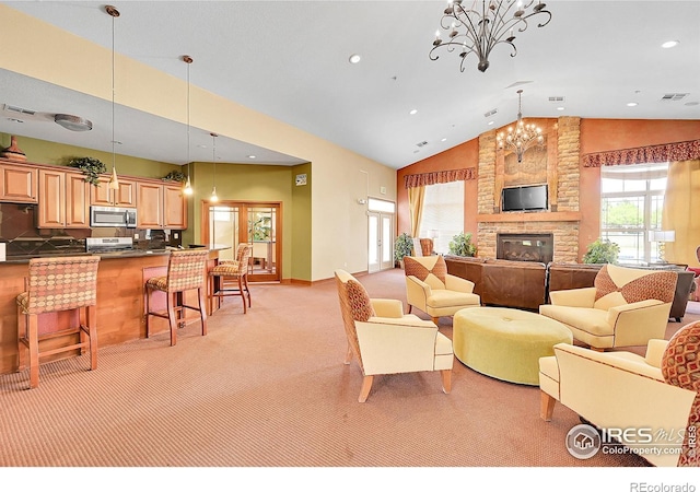 living area featuring light carpet, visible vents, a chandelier, a large fireplace, and high vaulted ceiling