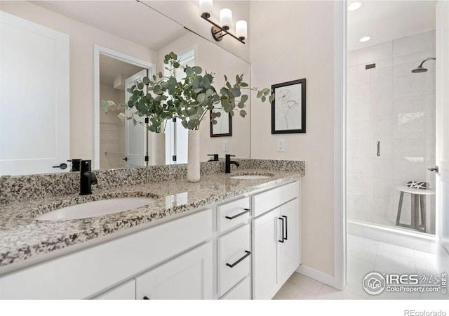bathroom with tile patterned floors, a sink, double vanity, and a stall shower
