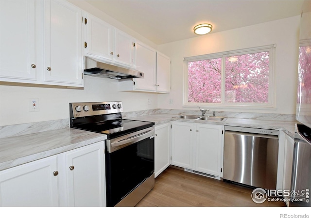 3465 Lochwood Dr Unit G-32, Fort Collins, CO 80525 - kitchen with light wood-style flooring, a sink, white cabinetry, under cabinet range hood, and appliances with stainless steel finishes