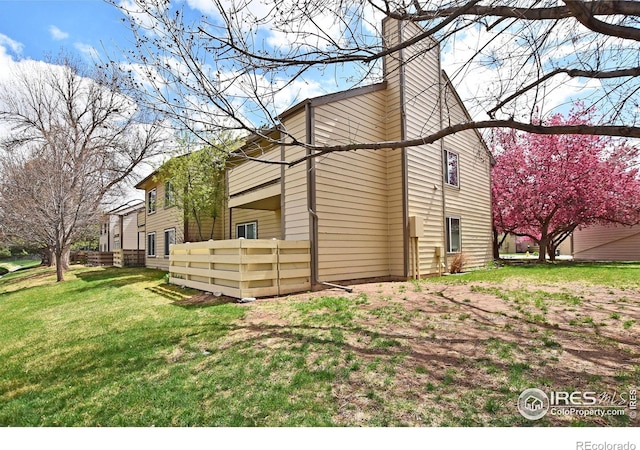 3465 Lochwood Dr Unit G-32, Fort Collins, CO 80525 - view of side of property featuring fence, a lawn, and a chimney