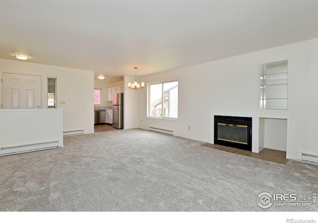 3465 Lochwood Dr Unit G-32, Fort Collins, CO 80525 - unfurnished living room with baseboard heating, a fireplace with flush hearth, a notable chandelier, and carpet