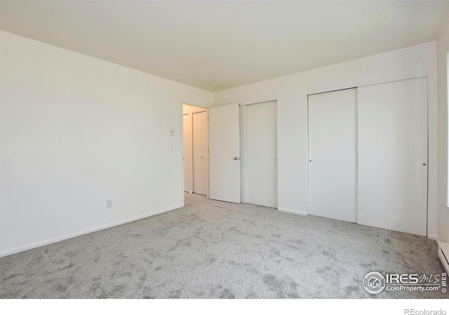 3465 Lochwood Dr Unit G-32, Fort Collins, CO 80525 - unfurnished bedroom featuring multiple closets, baseboards, and carpet floors