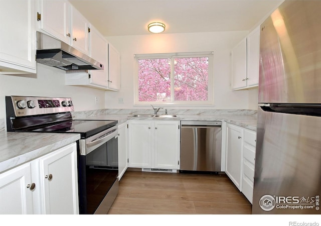 3465 Lochwood Dr Unit G-32, Fort Collins, CO 80525 - kitchen with white cabinetry, appliances with stainless steel finishes, under cabinet range hood, and a sink