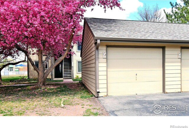 3465 Lochwood Dr Unit G-32, Fort Collins, CO 80525 - exterior space with a shingled roof, an outdoor structure, stairs, and a garage