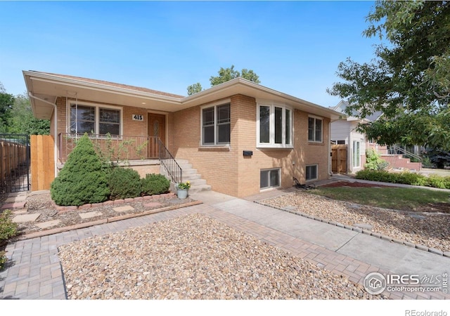 view of front of property featuring brick siding and fence
