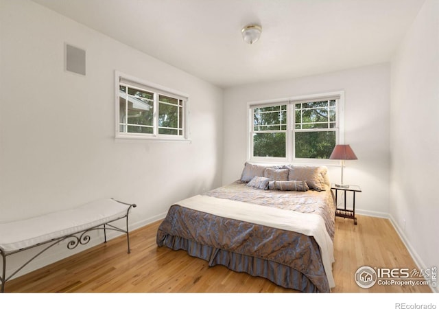 bedroom with baseboards and wood finished floors
