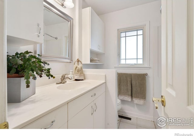 bathroom with toilet, vanity, tile patterned floors, and visible vents