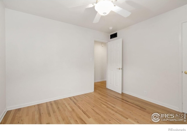 spare room featuring ceiling fan, baseboards, wood finished floors, and visible vents
