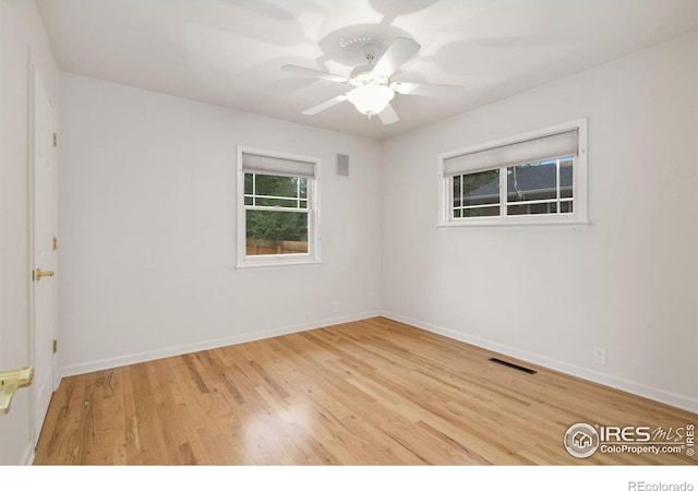 empty room featuring ceiling fan, baseboards, wood finished floors, and visible vents