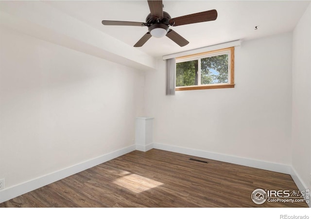 empty room featuring baseboards, a ceiling fan, wood finished floors, and visible vents