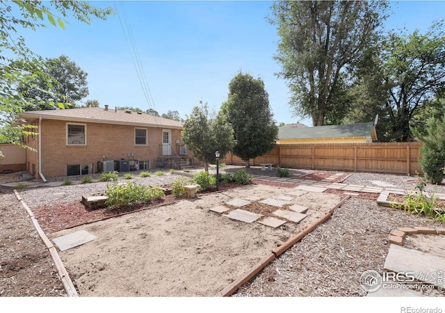 view of yard featuring cooling unit, a vegetable garden, and fence