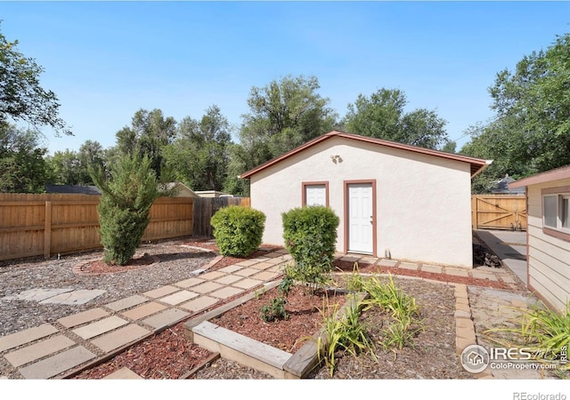 view of outdoor structure with a fenced backyard and an outbuilding