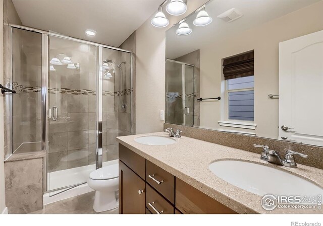 8482 Parkland St, Broomfield, CO 80021 - full bath featuring a shower stall, toilet, double vanity, and tile patterned floors