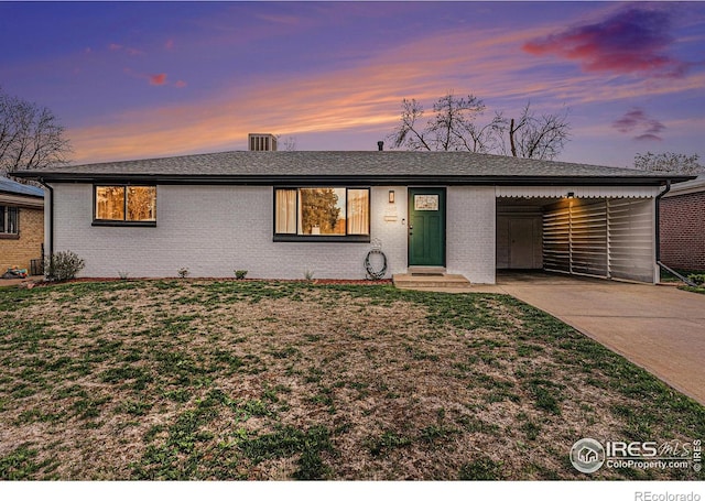 2566 S Stuart St, Denver, CO 80219 - single story home with an attached carport, driveway, a yard, and brick siding