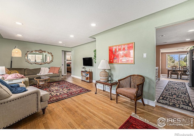 2566 S Stuart St, Denver, CO 80219 - living room with wood finished floors, recessed lighting, baseboards, and a textured ceiling
