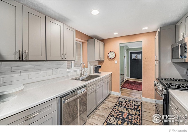 2566 S Stuart St, Denver, CO 80219 - kitchen featuring appliances with stainless steel finishes, a sink, gray cabinetry, baseboards, and recessed lighting