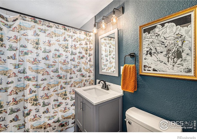 2566 S Stuart St, Denver, CO 80219 - bathroom featuring a textured wall, vanity, toilet, and a shower with curtain