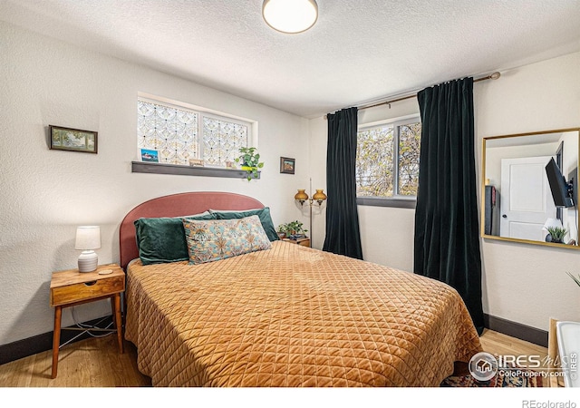 2566 S Stuart St, Denver, CO 80219 - bedroom with wood finished floors, a textured ceiling, and baseboards