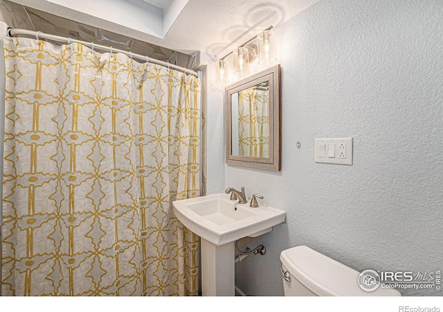 2566 S Stuart St, Denver, CO 80219 - full bath with toilet, a textured wall, and a shower with shower curtain
