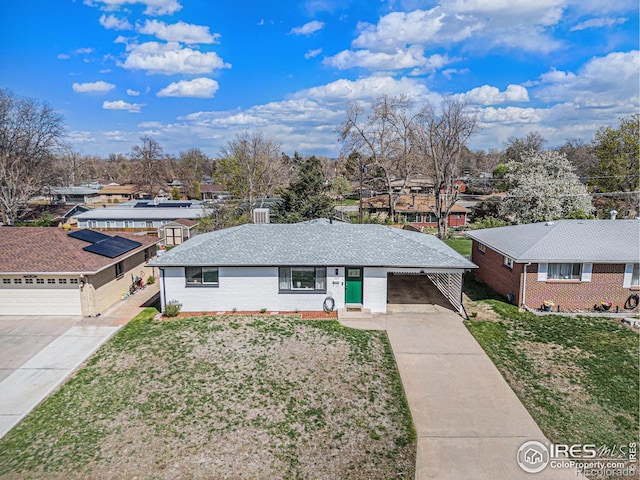 2566 S Stuart St, Denver, CO 80219 - ranch-style home featuring driveway, a front lawn, a residential view, brick siding, and an attached carport