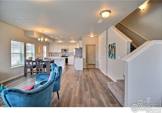 1693 Grand Ave Unit 1, Windsor, CO 80550 - living room with stairs, a chandelier, wood finished floors, baseboards, and recessed lighting