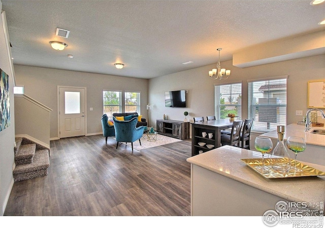 1693 Grand Ave Unit 1, Windsor, CO 80550 - living area with dark wood-style flooring, a chandelier, baseboards, a textured ceiling, and stairs