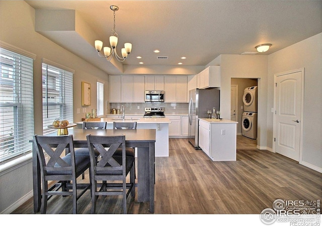 1693 Grand Ave Unit 1, Windsor, CO 80550 - kitchen with appliances with stainless steel finishes, stacked washer / drying machine, light countertops, baseboards, and recessed lighting