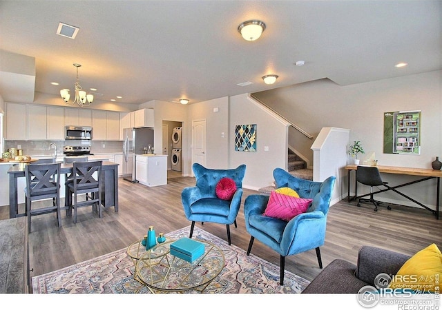 1693 Grand Ave Unit 1, Windsor, CO 80550 - living room featuring a chandelier, light wood-style flooring, stairway, recessed lighting, and baseboards